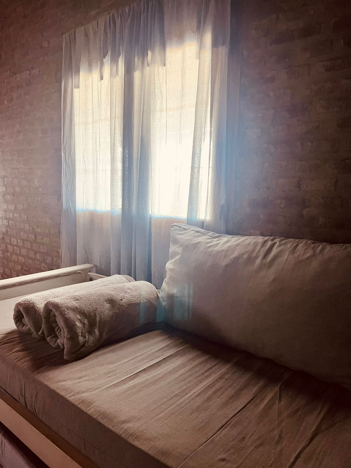 Dormitorio con luz natural y cortinas blancas