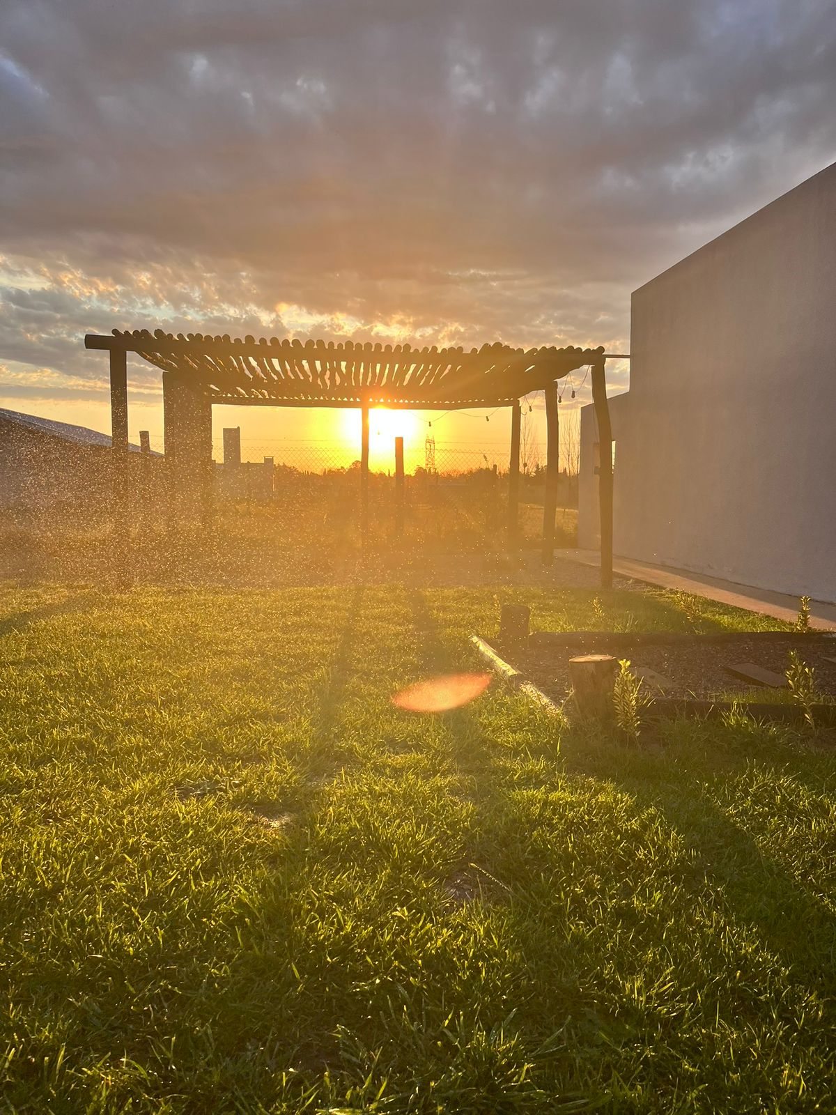 Atardecer dorado sobre la pérgola del jardín
